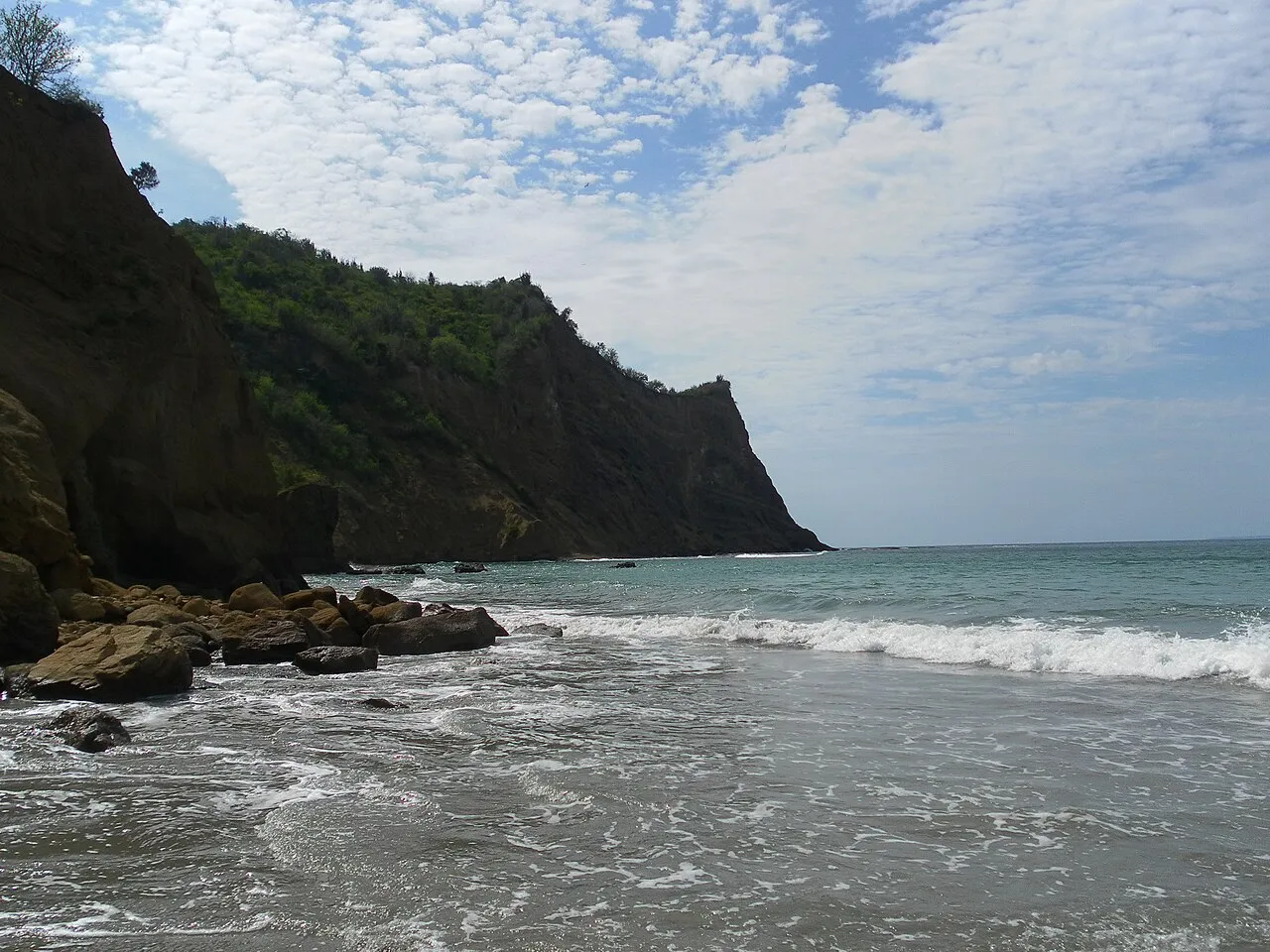 Olas del Pacífico rompiendo en la playa Los Frailes, rodeada de acantilados verdes