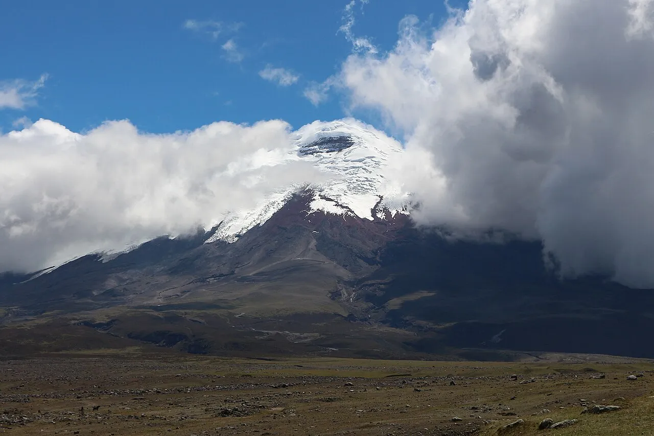 El volcán Cotopaxi cubierto de nieve y nubes sobre el páramo